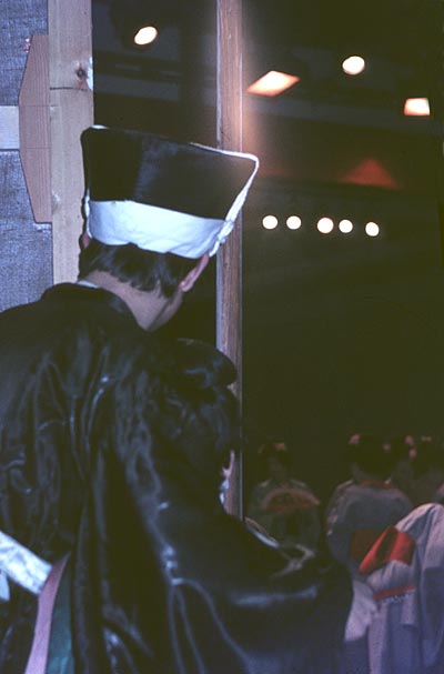 David Hails, as Ko Ko, peeks onto the stage